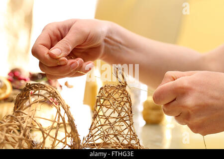 Fabbricazione di giocattoli decorazioni in legno, campane. Albero di natale toy campane bastoni intrecciato. Le decorazioni di Natale Foto Stock