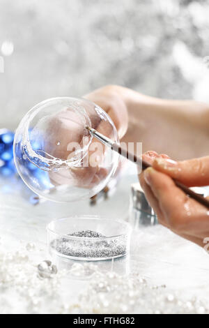 Pittura palle di Natale. Fabbricazione e artigianato. Donna decorare baubles. Addobbi per l'albero di natale Foto Stock