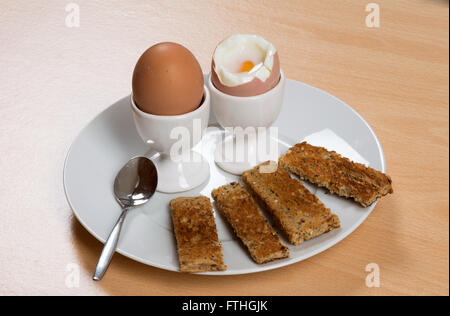 Colazione a base di uova sode e toast soldati su una piastra Foto Stock