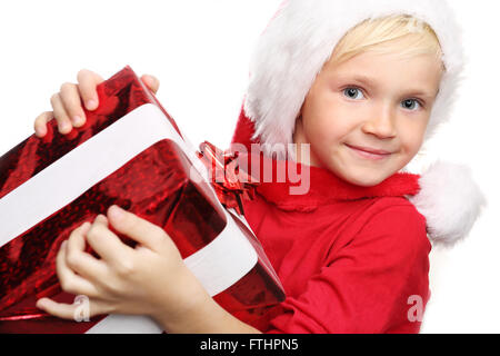 Sogni di natale, magico periodo natalizio. Bambino felice nel cappuccio di San Nicola di regalo confezionato Foto Stock