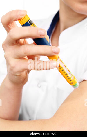 Una donna di insulina iniettata nel braccio Foto Stock
