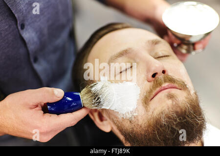 La formazione di schiuma di crema per la rasatura Foto Stock