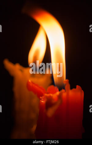 Due candele accese nel buio closeup Foto Stock