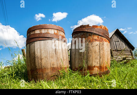 Vecchie botti in legno presso il villaggio in estate Foto Stock