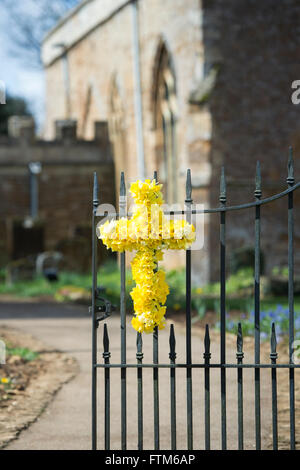 Pasqua Daffodil croce sulle porte di San Pietro e San Paolo chiesa. Kings Sutton, Banbury, Northamptonshire, Inghilterra Foto Stock