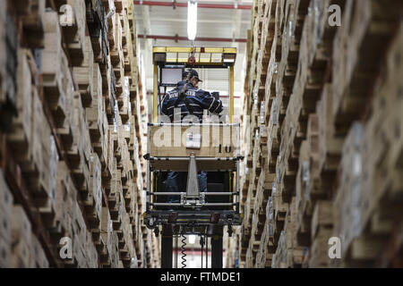 Workman utilizzando un carrello elevatore per la movimentazione di pezzi di ricambio in magazzino dalla linea di produzione Foto Stock