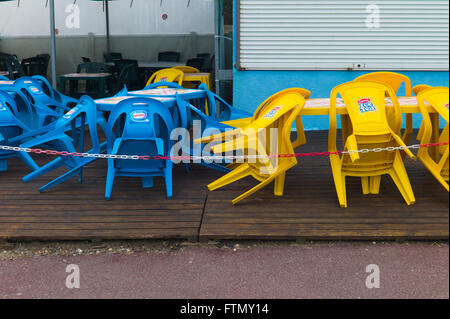 Impilate i colori giallo e blu in plastica Sedie ristorante Foto Stock