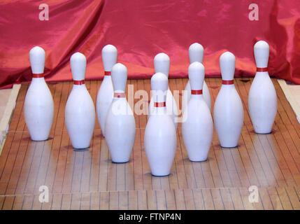 Un set di decine i pin su una tavola di legno di Bowling. Foto Stock