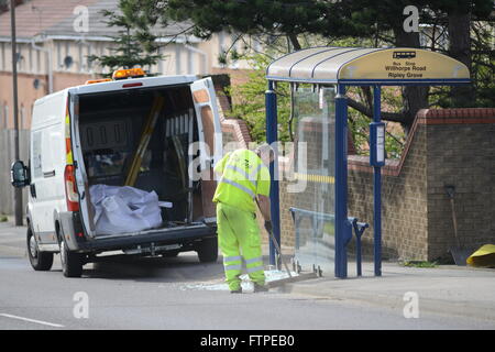 Un uomo che spazia fino alla rottura di un vetro della finestra su un soggetto ad atti vandalici fermata bus a Barnsley, South Yorkshire, Regno Unito. Foto Stock