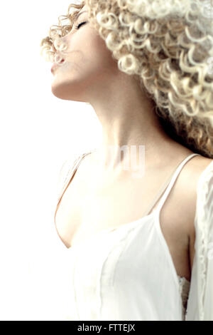 Curly donna bionda nel vento Foto Stock