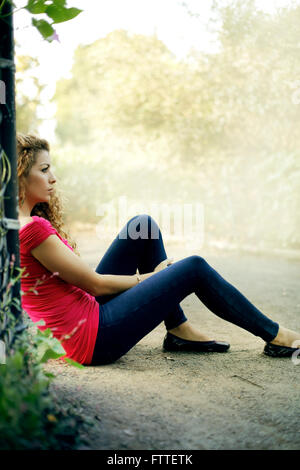 Casual giovane donna seduta in posizione di parcheggio Foto Stock