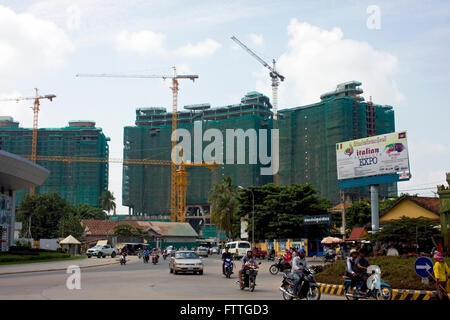 Nuovi edifici in costruzione torre al di sopra di una strada di città in Phnom Penh Cambogia. Foto Stock