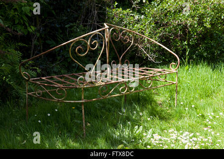 Vecchi mobili da giardino realizzati in ferro etc seduto in un giardino sovradimensionate. Foto Stock
