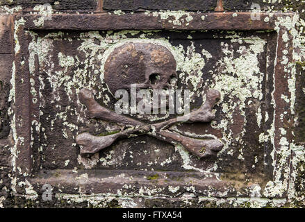 Un close-up di un teschio su una lapide in un cimitero. Foto Stock