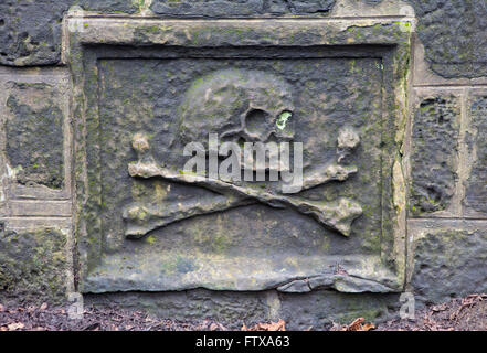 Un close-up di un teschio su una lapide in un cimitero. Foto Stock