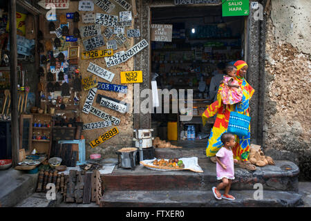 Un magazzino generale in uno di Stone Town s un labirinto di stradine strette, Zanzibar, Tanzania. Le targhe delle auto in vendita. Foto Stock