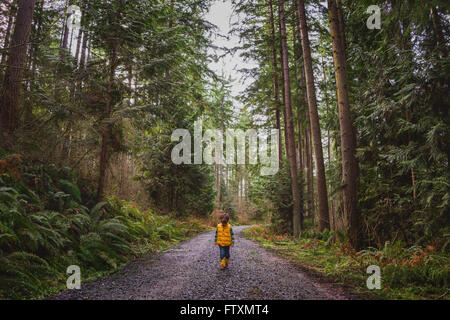 Ragazzo camminando lungo il sentiero forestale Foto Stock