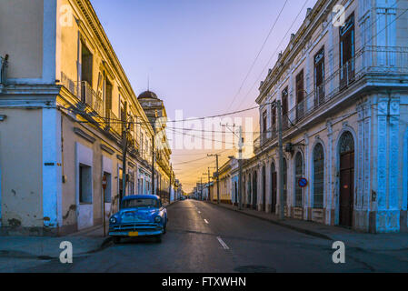 Classis automobile in strada della Vecchia Havana, Cuba. Baclight con Rising Sun rais e lunghe ombre. Foto Stock