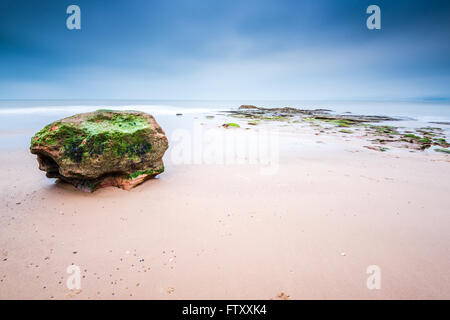 Il Red rock formazione a Exmouth beach nel Devon, Regno Unito. Una lunga esposizione blured acqua di mare. Foto Stock