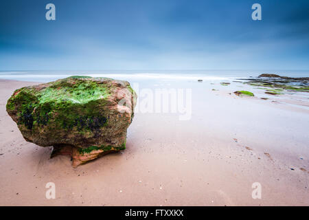 Il Red rock formazione a Exmouth beach nel Devon, Regno Unito. Una lunga esposizione blured acqua di mare. Foto Stock