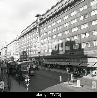 Anni '1950, vista storica di Oxford Street, Londra, Inghilterra, Regno Unito che mostra gli autobus a due piani dell'epoca e un grande blocco di appartamenti sopra il grande magazzino di Thomas Wallis al 490 di Oxford Street. Foto Stock