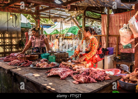 Donna asiatica macellaio vende carne ad un mercato locale di Yangon Foto Stock