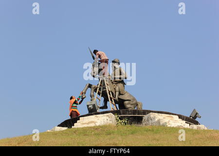 Un uomo e una donna pulire la statua di Bhai Fateh Singh a Baba Banada Singh Bahadur Sikh Memorial Gardens Foto Stock