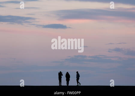 La gente ha silhoueted contro un cielo colorato. Credit: Ian Jones/Alamy Live News Foto Stock