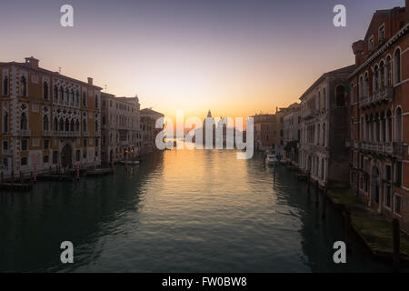 Misty sunrise sul Canal Grande di Venezia con una voce di traghetto verso la Basilica di Santa Maria della Salute Foto Stock