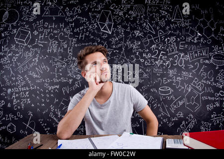 Hipster studente facendo il suo dovere nei confronti di una grande lavagna Foto Stock