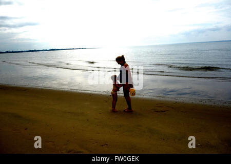 Donna incinta con la figlia kissing ventre Foto Stock