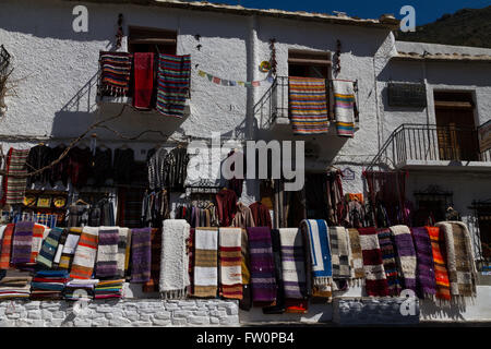 I tappeti tradizionali appendere fuori shopes nel villaggio andaluso di Pampaneira nella Alpujarras Foto Stock