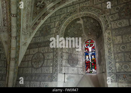 Parete vittoriano stenciling e vetrata nel santuario di St Georges Chiesa, Hampnet, Cotswolds, Inghilterra Foto Stock