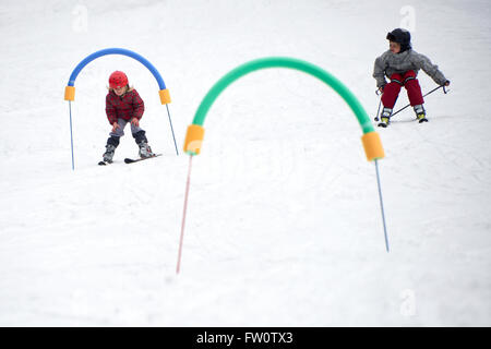 Sci bambini in montagna. Il Toddler kid in tuta da sci e casco di sicurezza imparare a sciare. I ragazzi di lezioni di sci nella scuola alpina. Foto Stock