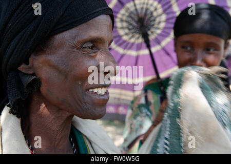 Tra Mojo e Ziway, Etiopia, Ottobre 2013: una giovane madre ripara il suo bambino figlio da sole forte con il suo ombrello. Fotografia di Mike Goldwater Foto Stock