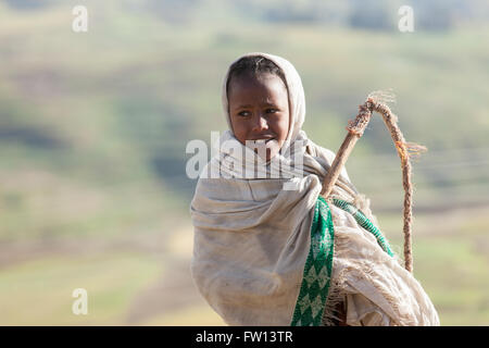 Villaggio Furamariam, Debele, Amhara, Etiopia, Ottobre 2013: Bambini imbrancandosi animali nella valle spazzate dal vento. Foto Stock