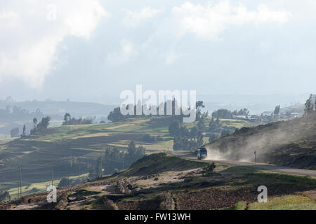 Villaggio Furamariam, Debele, Amhara, Etiopia, Ottobre 2013: un bus calci fino la polvere sulla strada attraverso la valle spazzate dal vento. Foto Stock