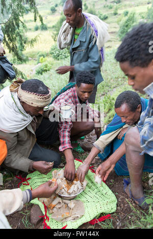 Wofwasha Kebele, Nord Shewa, Etiopia, Ottobre 2013: mangiare un pasto di injera fornito da un allevatore locale. Foto Stock