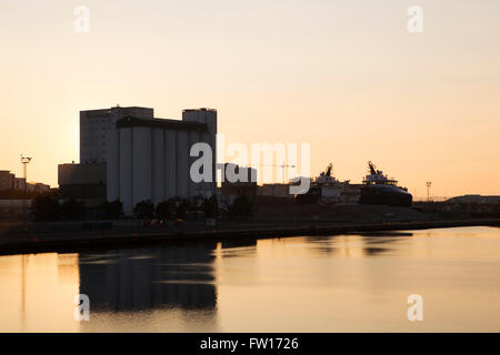 Mulino di farina a Leith Docks di Edimburgo, in Scozia. Il sole tramonta oltre i silos. Foto Stock