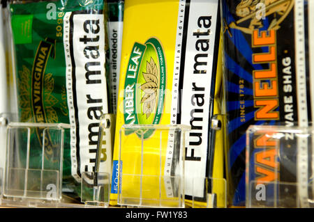 Selezione di mano il tabacco da arrotolare in vendita in una tabaccheria. Foto Stock