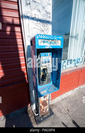 Un grafitti coperti e trascurato pubblico cabina telefonica su un angolo di strada nel mercato Kensington District di Toronto in Canada Foto Stock