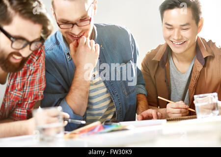 Un gruppo di giovani designer discutendo insieme Foto Stock
