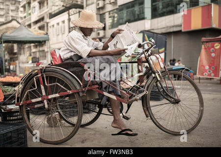 YANGON, MYANMAR - Gennaio 3, 2016: Unidentified in trishaw driver su una pausa per le strade di Yangon , il Myanmar il 3 gennaio 2016 Foto Stock