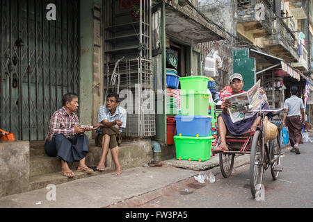 YANGON, MYANMAR - Gennaio 3, 2016: Uomini non identificati avente una pausa per le strade di Yangon , il Myanmar il 3 gennaio 2016 Foto Stock