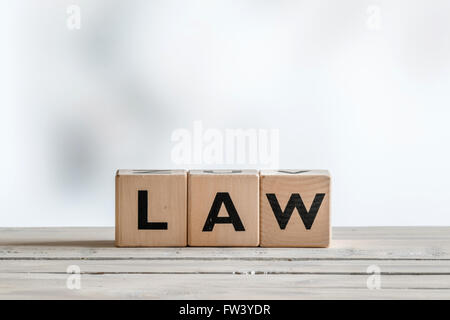 Legge segno su una scrivania di legno su sfondo bianco Foto Stock