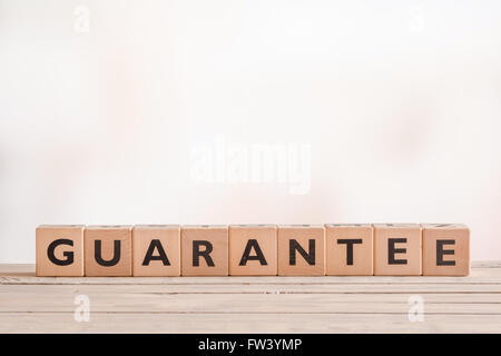 Garantire il segno fatto di blocchi su una scrivania in legno Foto Stock