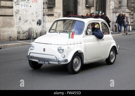 Una Fiat 500 con bandiere italiane per le strade di Roma, Italia. Presto divenne un simbolo italiano Foto Stock