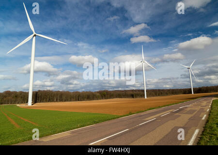 Tre turbine eoliche in una fila in una strada di campagna in Francia. Foto Stock