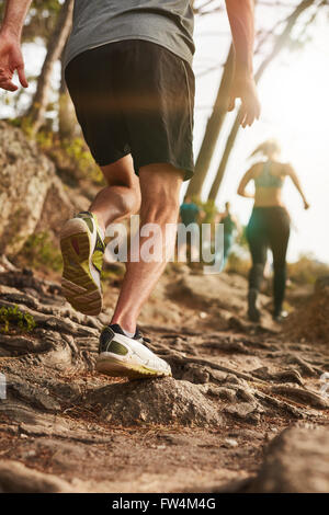 Closeup colpo di un maschio di runner su terreni accidentati all'esterno. Trail Running allenamento sulla collina. Foto Stock