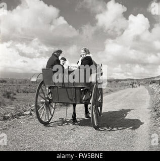 Anni '50, storica, una famiglia rurale irlandese che viaggia su un cavallo e intrappola lungo una corsia di campagna nell'Irlanda occidentale in questa foto di J Allan Cash. Foto Stock